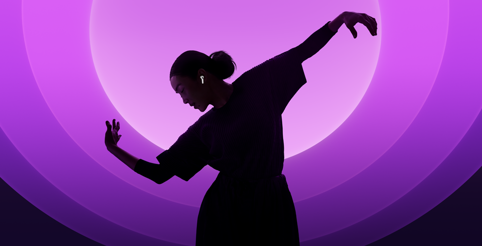 Una persona baila con unos AirPods 5 puestos, fondo multicolor