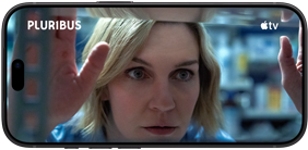iPhone 18 Pro, posición horizontal, muestra un primer plano de una mujer mirando a través de una estantería. Título de la serie: Pluribus