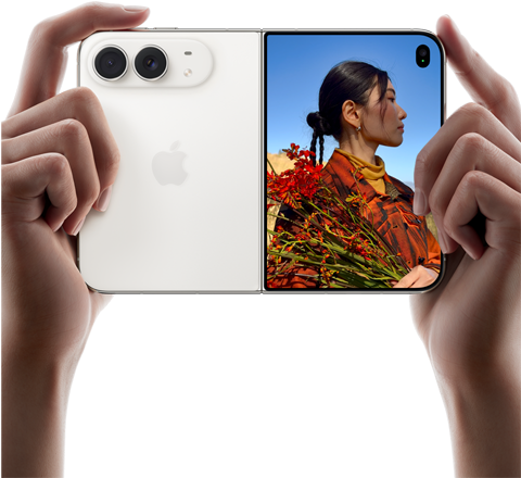 iPhone Duo, color blanco estelar, sujetado por dos manos en horizontal, abierto. Izquierda: sistema de cámaras traseras dual Fusion de 48 Mpx. Derecha: una persona siendo fotografiada en la pantalla exterior. La persona fotografiada puede verse en la pantalla con Duo Preview mientras le hacen la foto.