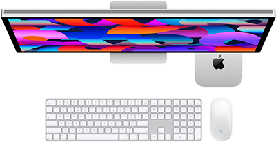 Mac mini debajo de un Studio Display, junto al Magic Keyboard con teclado numérico y el Magic Mouse