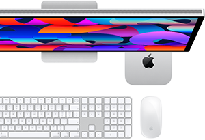 Mac mini debajo de un Studio Display, junto al Magic Keyboard con teclado numérico y el Magic Mouse
