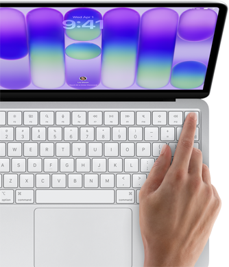 MacBook Neo, color plata, pantalla de inicio de sesión, dedo de una persona apoyado sobre el sensor Touch ID en la esquina superior derecha del teclado
