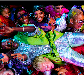 MacBook Pro con la pantalla a todo color que muestra a una persona llevada en volandas en una fiesta, destaca la nitidez de la pantalla Liquid Retina XDR