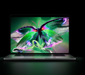 MacBook Pro con pantalla PROLED XDR, tapa abierta, color plata, la pantalla muestra una imagen detallada de alto contraste con colores vivos, la pantalla ilumina el teclado